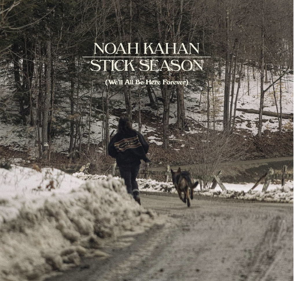 Photo of a man and a dog running on a trail in the woods with snow on the ground surrounding them. Bolded at the top of the picture are the words Noah Kahan- Stick Season, and written smaller underneath it says We’ll All Be Here Forever.